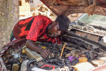 Photo for Karara, Nasarawa State - May 5, 2021: African Male Mechanic Fixing a Car Brokendown in a Rural Community with his Friend - Royalty Free Image