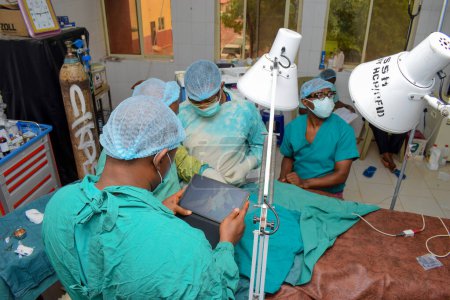 Foto de Abuja, Nigeria - 06 de mayo de 2021: Cirujano plástico africano y miembros del equipo realizan un procedimiento quirúrgico en un teatro médico - Imagen libre de derechos