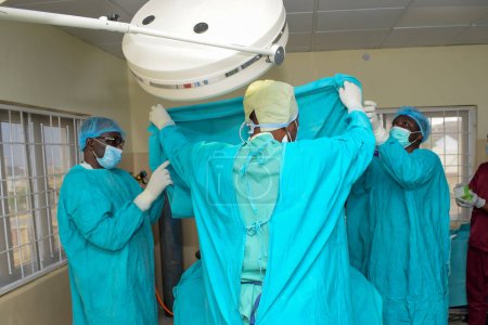 Photo for Abuja Nigeria - May 06, 2021: African Plastic Surgeon and Team Members Performing a Surgical Procedure in a Medical Theatre - Royalty Free Image