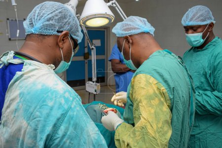 Foto de Abuja Nigeria - 06 de mayo de 2021: Cirujano plástico africano y miembros del equipo realizan un procedimiento quirúrgico en un teatro médico - Imagen libre de derechos