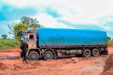 Téléchargez les photos : Loko, Nasarawa, Nigéria - 06 août 2021 : Route boueuse pendant la saison des pluies. Véhicules coincés sur une mauvaise route et causant un accident. - en image libre de droit