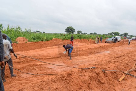Foto de Loko, Nasarawa, Nigeria - 06 de agosto de 2021: Muddy road during rainy season. Vehículos atascados en la carretera y causando un accidente. - Imagen libre de derechos