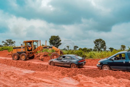 Foto de Loko, Nasarawa, Nigeria - 06 de agosto de 2021: Muddy road during rainy season. Vehículos atascados en la carretera y causando un accidente. - Imagen libre de derechos