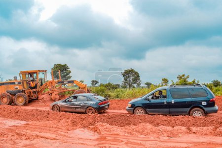 Téléchargez les photos : Loko, Nasarawa, Nigéria - 06 août 2021 : Route boueuse pendant la saison des pluies. Véhicules coincés sur une mauvaise route et causant un accident. - en image libre de droit