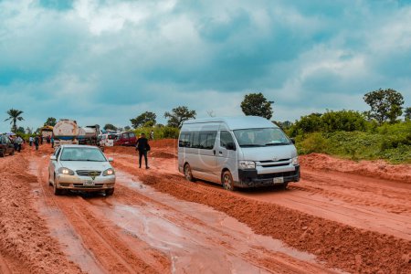Photo for Loko, Nasarawa, Nigeria - August 06, 2021: Muddy road during rainy season. Vehicles stuck on bad road and causing accident. - Royalty Free Image
