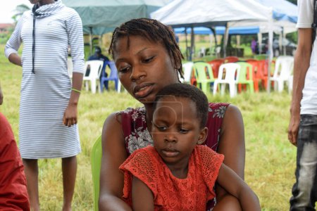 Téléchargez les photos : Aluu, Port Harcourt - 10 août 2021 : Africains en attente de soins médicaux gratuits et d'attention dans une communauté rurale. Les gens s'inscrivent pour voter aux élections. Exercice de campagne politique - en image libre de droit
