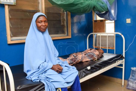 Téléchargez les photos : Abuja, Nigéria - 6 septembre 2021 : Une mère africaine prend soin de son enfant malade dans une clinique rurale - en image libre de droit