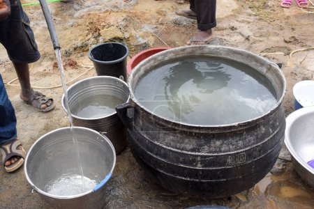 Foto de Abuja Nigeria - 02 de septiembre de 2021: Prueba de bombeo de agua en la comunidad rural africana. Prueba de la capacidad de la bomba del pozo del agujero. Implementación del Proyecto de Agua Limpia Rural para Comunidades Indigentes en África. - Imagen libre de derechos
