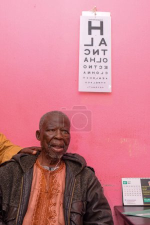 Téléchargez les photos : Abuja, Nigéria - 09 août 2021 : Le Moyen Âge visite un médecin pour une consultation oculaire en clinique rurale. Contrôle oculaire et test oculaire - en image libre de droit