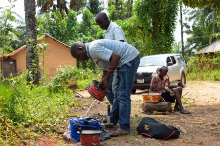 Foto de Abuja, Nigeria - 28 de octubre de 2021: Geólogos africanos y miembros del equipo realizan una encuesta geofísica sobre la disponibilidad de agua en el suelo. Ciencias y pruebas del suelo. Proyecto Agua Rural. - Imagen libre de derechos
