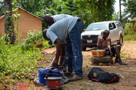 Téléchargez les photos : Abuja, Nigéria - 28 octobre 2021 : Géologues africains et membres de l'équipe menant une enquête géophysique sur la disponibilité de l'eau sur le terrain. Science et test du sol. Projet d'eau rurale. - en image libre de droit
