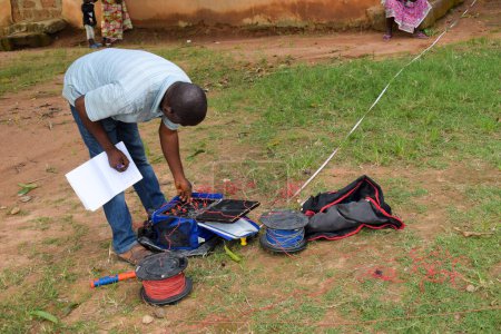 Téléchargez les photos : Abuja, Nigéria - 28 octobre 2021 : Géologues africains et membres de l'équipe menant une enquête géophysique sur la disponibilité de l'eau sur le terrain. Science et test du sol. Projet d'eau rurale. - en image libre de droit