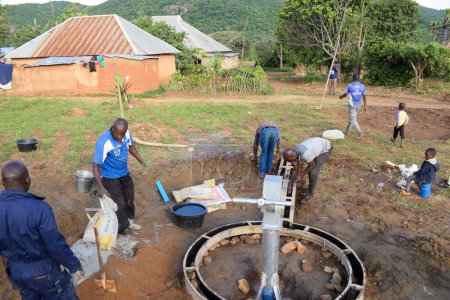Foto de Jos East, Plateau State, Nigeria - 12 de mayo de 2021: Instalación de pozos de agua con bomba manual en comunidades rurales. Objetivos de los ODS en Nigeria África. Grupo de africanos que trabajan en la instalación de pozo de agua bomba de mano. - Imagen libre de derechos