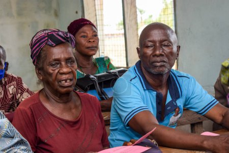 Téléchargez les photos : Karara, État de Nasarawa - 5 mai 2021 : Personnes âgées africaines âgées assis sur une chaise et en attente d'une file d'attente pour les soins médicaux et l'attention dans une communauté rurale - en image libre de droit