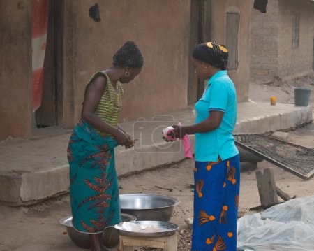 Téléchargez les photos : Opialu, État de Benue - 6 mars 2021 : Des femmes africaines travailleuses engagées dans son activité dans sa communauté - en image libre de droit