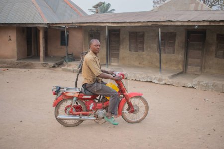 Foto de Opialu, Benue State - 6 de marzo de 2021: El agricultor africano y el padre se dirigen a la granja en su motocicleta - Imagen libre de derechos