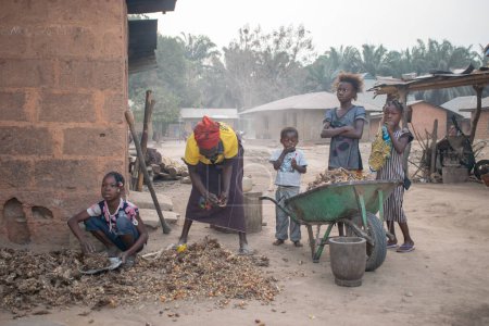 Photo for Opialu, Benue State - March 6, 2021: African Mother and Children Working Together - Royalty Free Image