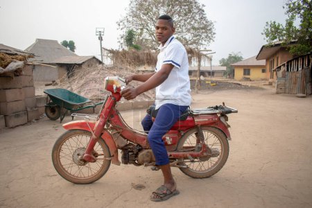Photo for Opialu, Benue State - March 6, 2021: Portrait of an African Student Riding on a Motor Bike - Royalty Free Image