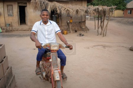 Photo for Opialu, Benue State - March 6, 2021: Portrait of an African Student Riding on a Motor Bike - Royalty Free Image