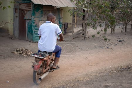Téléchargez les photos : Opialu, État de Benue - Mars 6, 2021 : Portrait d'un étudiant africain chevauchant une moto - en image libre de droit