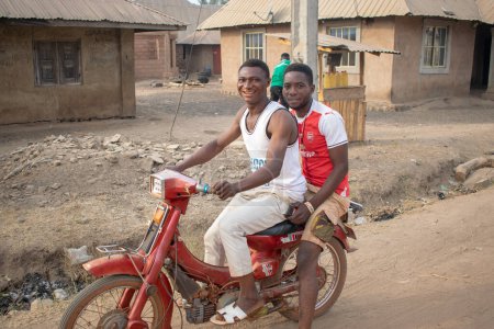 Foto de Opialu, Estado de Benue, Nigeria - 6 de marzo de 2021: retrato de dos hombres africanos sentados en bicicleta - Imagen libre de derechos
