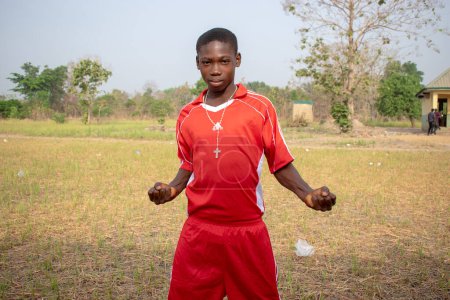 Téléchargez les photos : Opialu, Benue State, Nigeria - mars 6, 2021 : Adolescent africain vêtu d'un maillot de sport coloré posant à la caméra - en image libre de droit