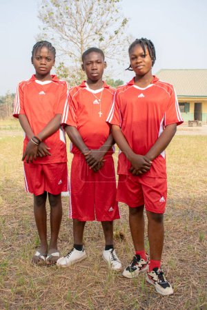 Photo for Opialu, Benue State, Nigeria - March 6, 2021: African teenager students dressed in colorful sport jersey posing on camera - Royalty Free Image