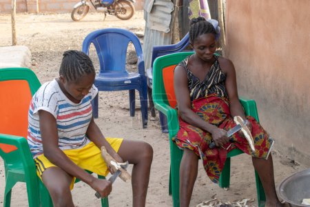 Téléchargez les photos : Opialu, État de Benue, Nigéria - 6 mars 2021 : Femmes africaines épluchant l'igname - en image libre de droit