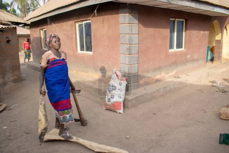Téléchargez les photos : Opialu, Benue Etat - mars 6, 2021 : Femme Africaine d'âge moyen vaquant à ses tâches du matin - en image libre de droit
