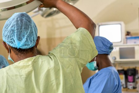 Foto de Jos, Plateau State - 5 de mayo de 2021: Cirujano africano en un teatro médico preparándose para una sesión de emergencia. Doctor en Exfoliantes - Imagen libre de derechos