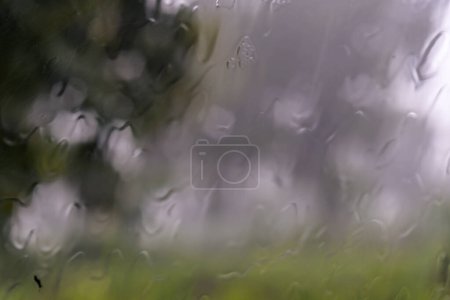 Foto de Lluvia a través de la pantalla de viento del coche en movimiento. Vista a través de la ventana del coche bajo la lluvia - Imagen libre de derechos
