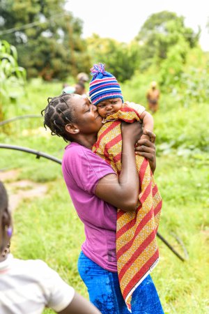 Photo for Abuja Nigeria - June 20, 2023: African Woman with Plated Hair holding baby boy - Royalty Free Image