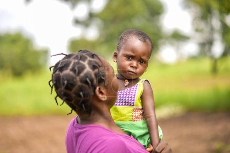 Téléchargez les photos : Abuja Nigeria - 20 Juin, 2023 : Femme africaine avec des cheveux plaqués tenant bébé fille - en image libre de droit