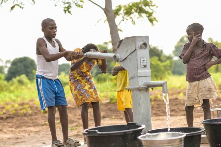 Photo for Talata, Plateau State - April 2, 2023: Indigenous African Kids Fetching Water from a Newly Built Indian Hand Pump. Community Members Fetching Water for Domestic Use. - Royalty Free Image