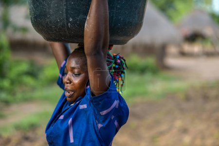 Téléchargez les photos : Talata, État du Plateau - Juin, 2023 : Femme africaine portant de l'eau - en image libre de droit