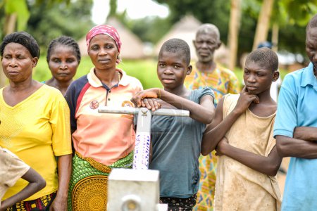 Photo for Talata, Plateau State - June, 2023: Community Members standing near Newly Built Indian Hand Pump - Royalty Free Image