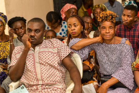 Téléchargez les photos : Abuja, Nigéria - 15 août 2023 : Assis en Afrique en attendant une file d'attente pour les soins médicaux et l'attention dans une communauté rurale. Campagne politique en Afrique - en image libre de droit