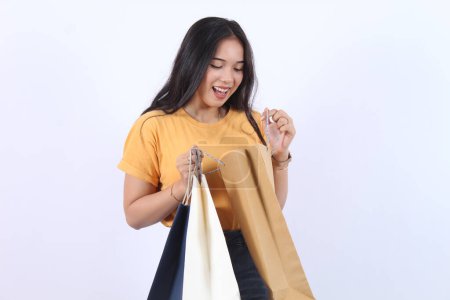 Asian happy female woman girl holds colourful shopping packages standing on white background studio shot, Close up Portrait young beautiful attractive girl smiling looking at camera with bags 