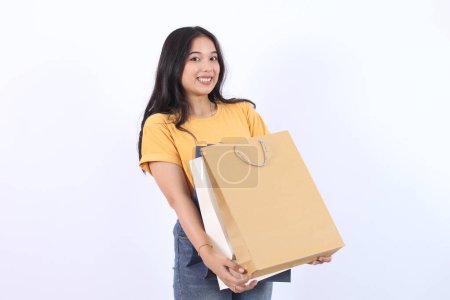 Asian happy female woman girl holds colourful shopping packages standing on white background studio shot, Close up Portrait young beautiful attractive girl smiling looking at camera with bags 