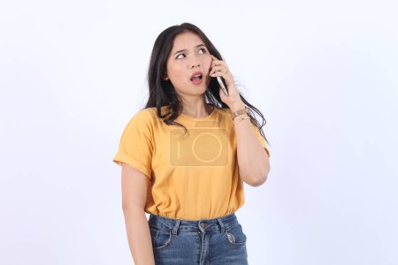 Friendly smiling asian woman talking on phone, girl on call, holding smartphone and laughing, speaking, standing over white background