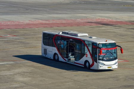 Téléchargez les photos : Un bus de l'aéroport appartenant à la compagnie aérienne Air asia se prépare à prendre les passagers qui descendent de l'avion à l'aire de trafic de l'aéroport international de Juanda, Indonésie, 29 juillet 2023. - en image libre de droit