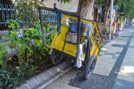 a janitor's trash cart parked on the sidewalk