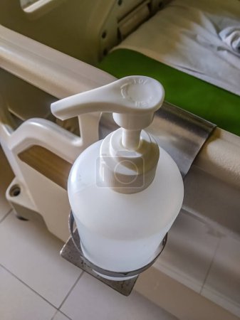 hand sanitizer attached to the hospital bed in the patient's room