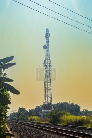 Téléchargez les photos : Une tour d'émetteur de communications cellulaires surplombant une voie ferrée à double voie - en image libre de droit