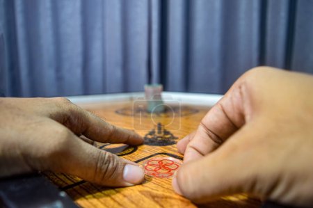 hands playing a traditional game called carom