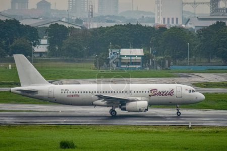 Téléchargez les photos : Un Airbus A320-232 appartenant à la compagnie aérienne Batik Air atterrit sur la piste de l'aéroport international Juanda, Surabaya à Sidoarjo, Indonésie, 6 janvier 2024 - en image libre de droit