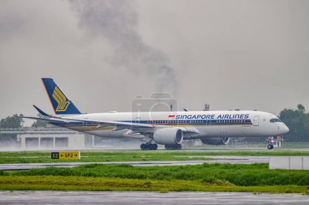 Téléchargez les photos : Un Airbus A350-941 appartenant à Singapore Airline décolle sur la piste de l'aéroport international Juanda Surabaya à Sidoarjo sous la pluie, Indonésie, 6 janvier 2024 - en image libre de droit