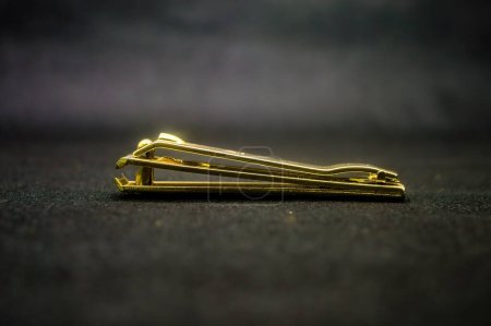 a gold nail clipper isolated on black background