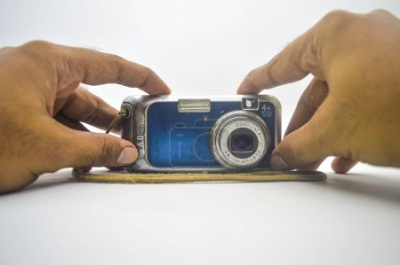 hand holding an old school pocket camera like a selfie isolated on white background