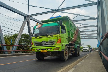 Foto de Un camión volquete Hino está pasando por un puente de armadura de acero, Indonesia, 16 de enero de 2024. - Imagen libre de derechos
